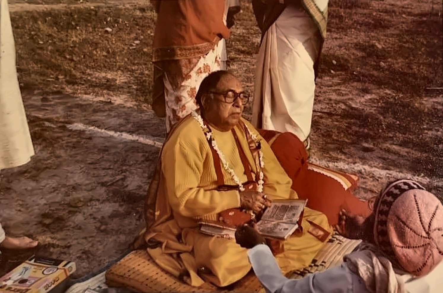 Expounding the scriptures to devotees, seated in the open